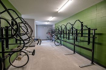 A bike rack with many bicycles parked in it.at Linc, Des Moines, 50309  